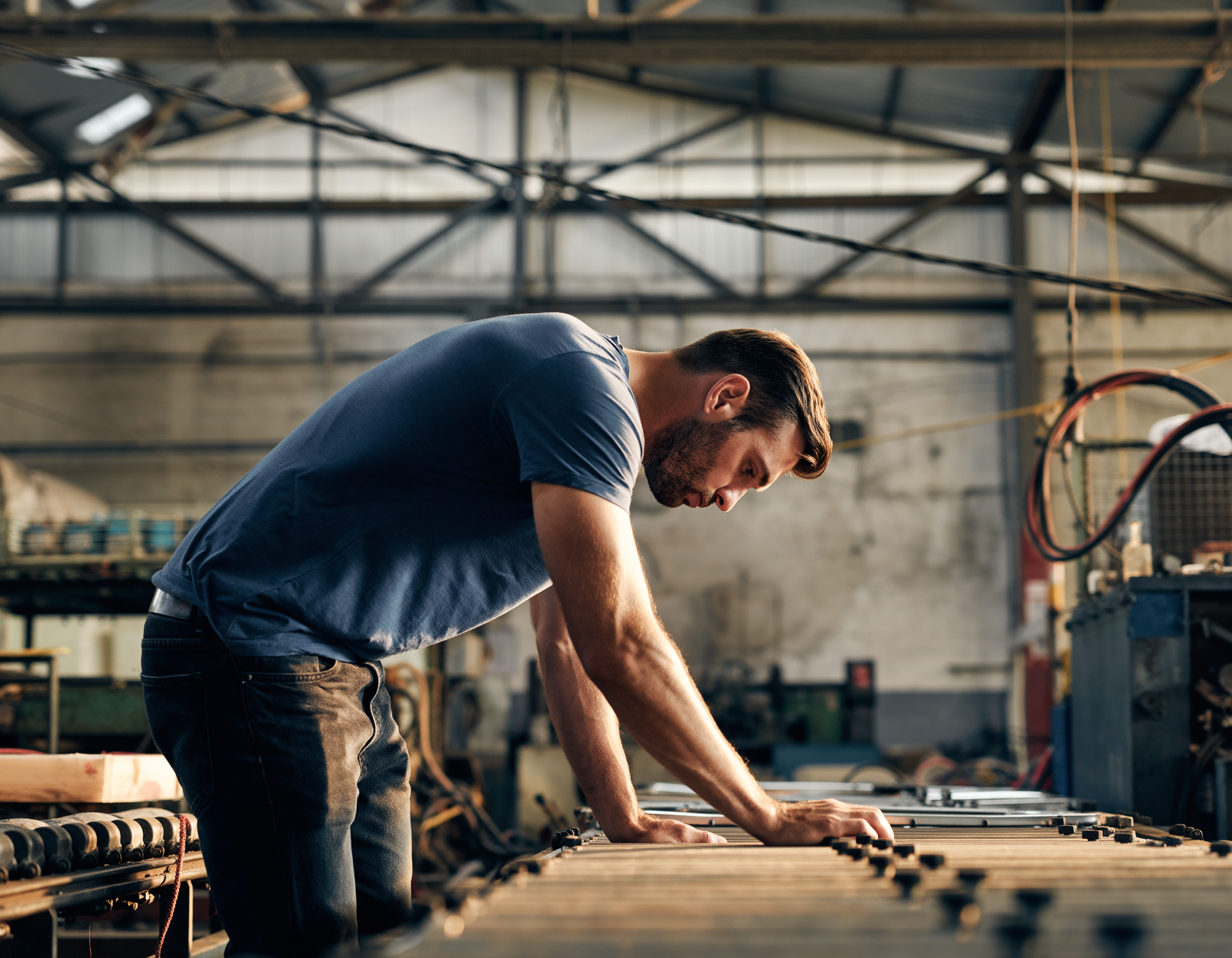 posture tms un ouvrier qui se tient vouté sur une chaine de production